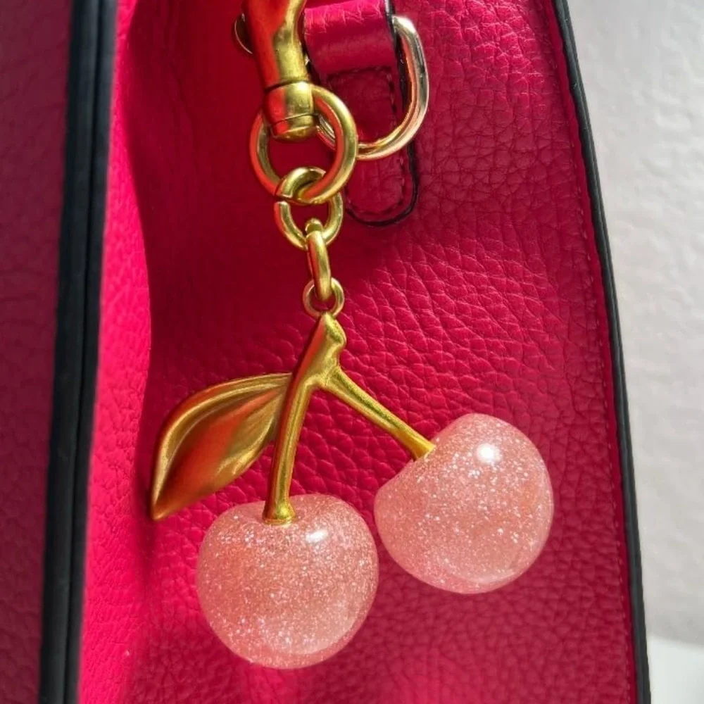 Cherry Pink sparkles with gold leaf clips onto your coach purse